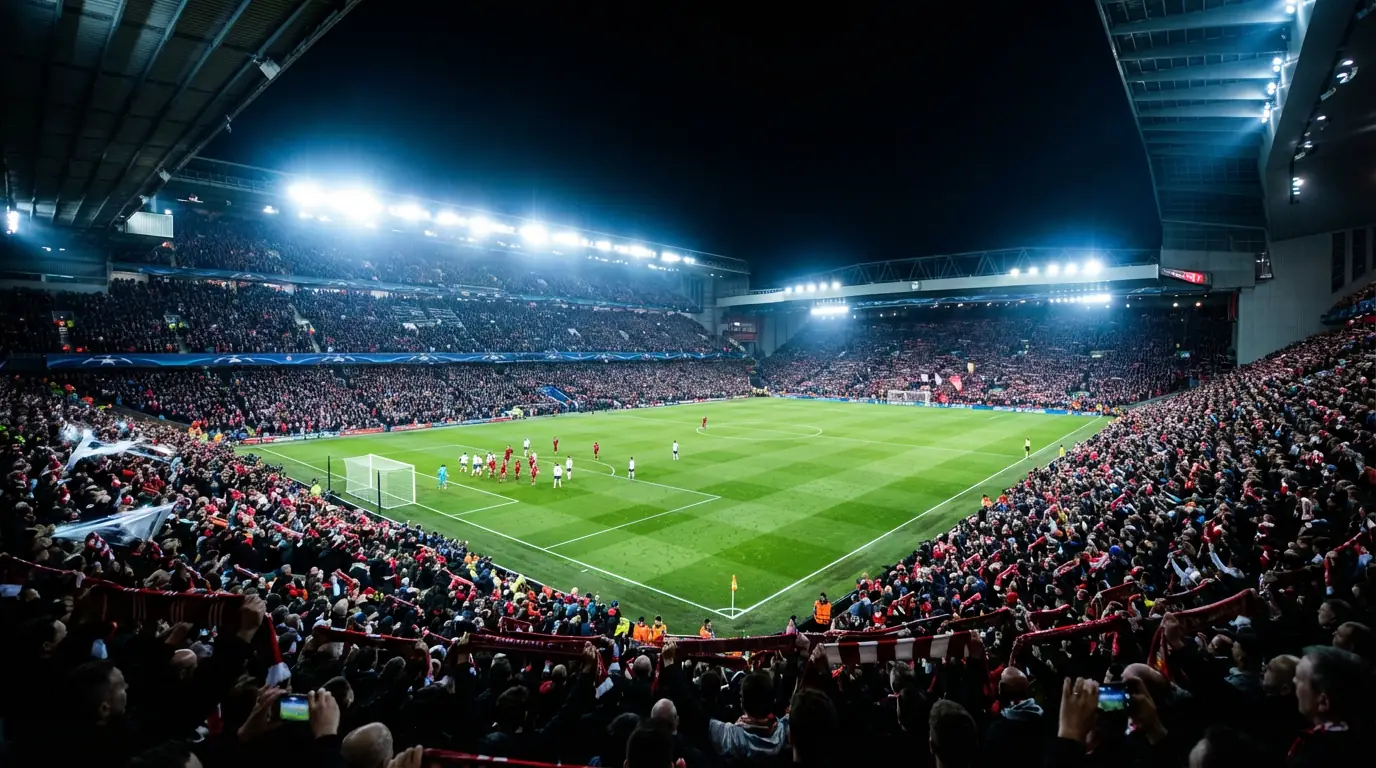 Stadio di calcio illuminato durante una serata di Champions League con spalti gremiti di tifosi